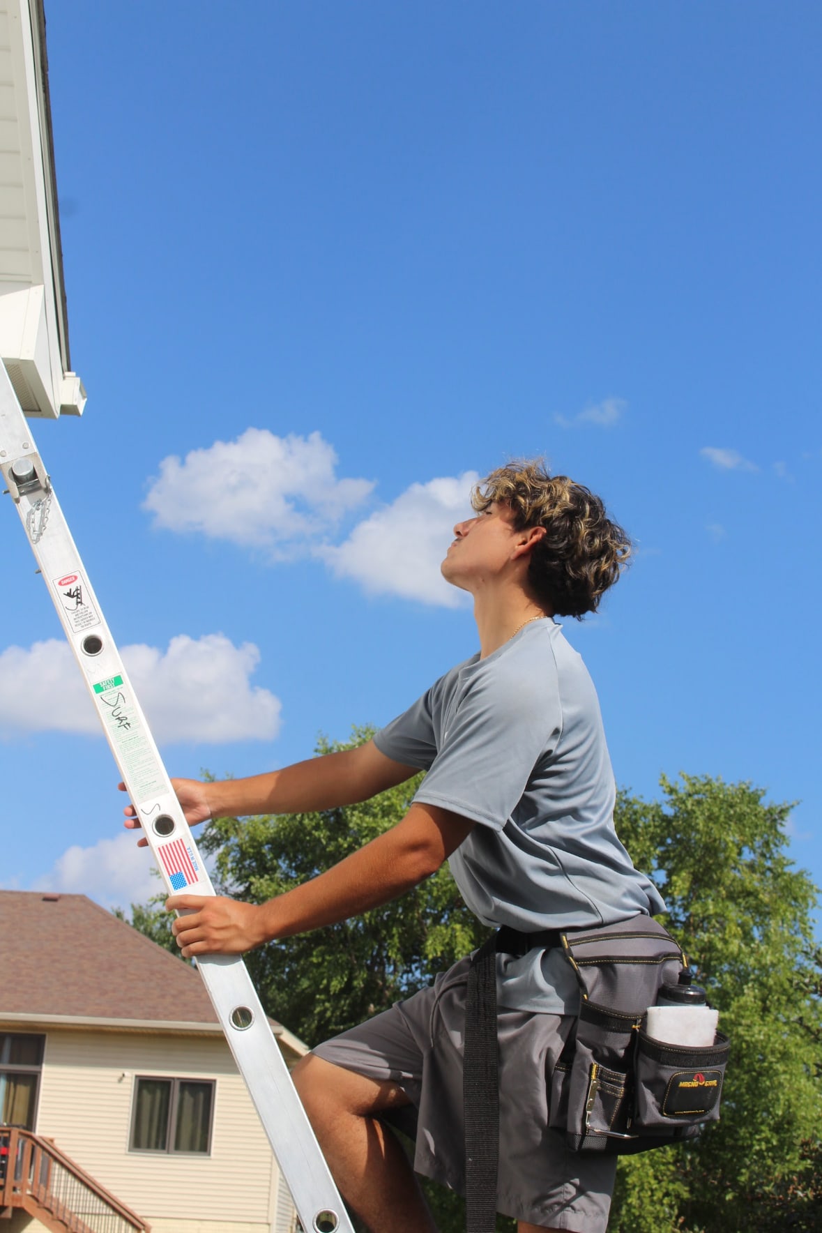 surf. technician climbing a ladder to reach second-story windows